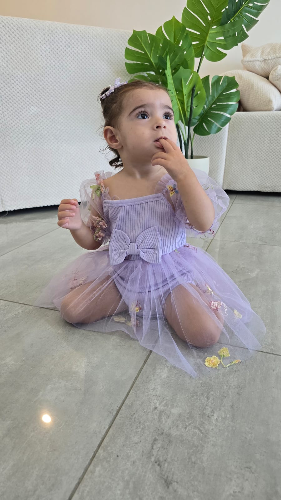 שמלה לתינוקות מעוטרת רקמות פרפרים ופרחים צבעוניים.